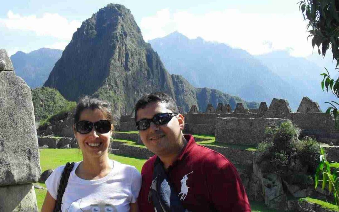 Dos viajeros posando con el Machu Pichu al fondo