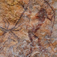 Pintura prehistórica de un arquero y un ciervo de color rojo